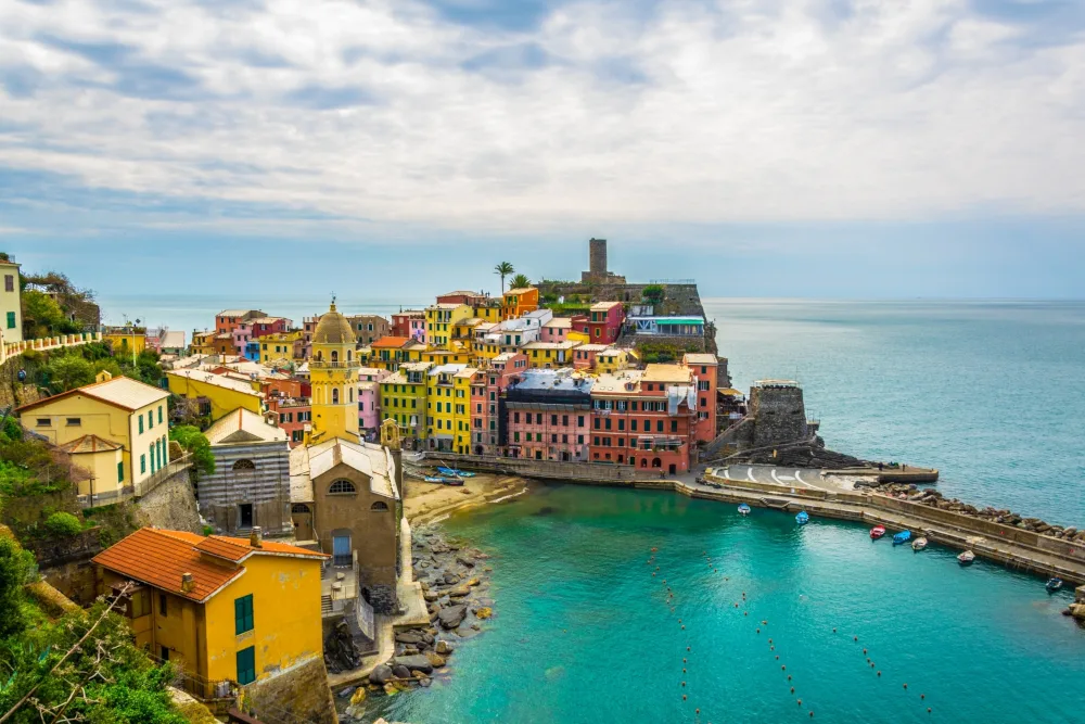 Panorama vibrant de Vernazza à Cinque Terre, eau turquoise et jetées