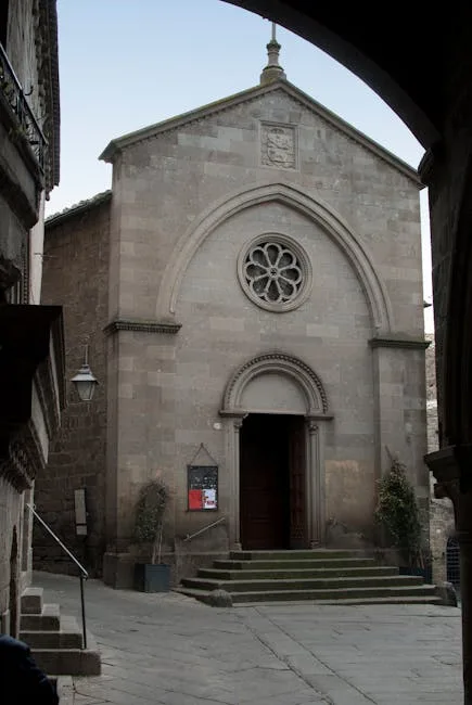 Oude stenen kerkgevel in smalle straat van een Cinque Terre-dorp