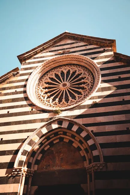 Façade rayée d'église avec rosace sculptée dans les Cinque Terre