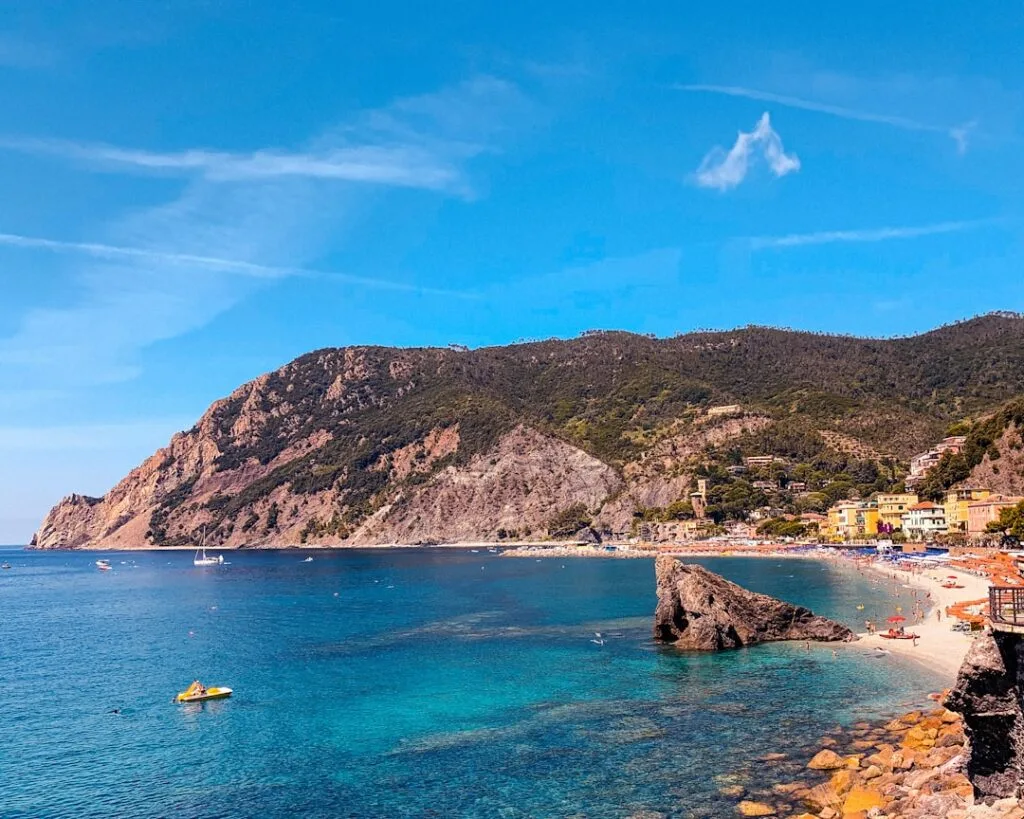 Strand en helderblauwe baai van Cinque Terre met rotsachtige kust