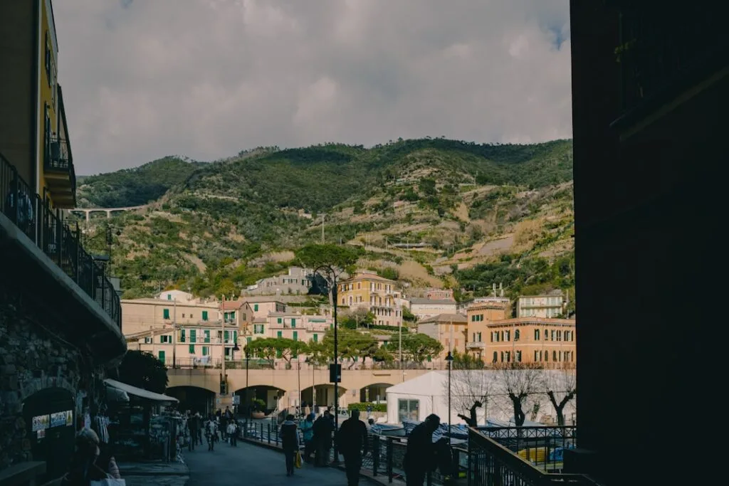 Promenade du bord de mer à Monterosso, passants et collines en arrière-plan