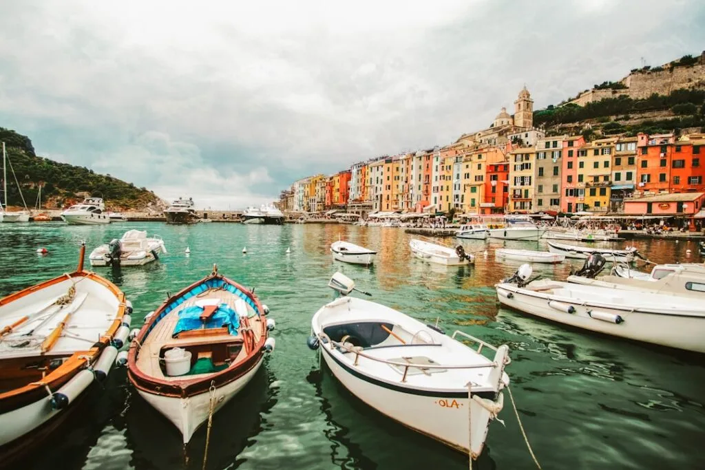 Bateaux amarrés dans un port turquoise face aux façades colorées d’un village ligure