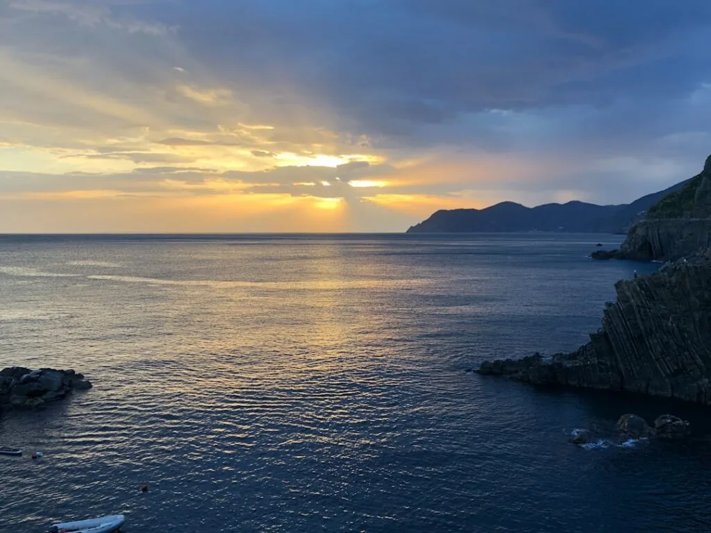 Coucher de soleil doré sur la mer et falaises des Cinque Terre.