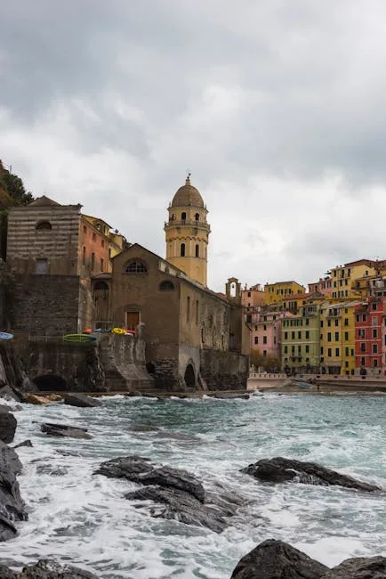 Église de Vernazza et rochers battus par les vagues sous ciel gris