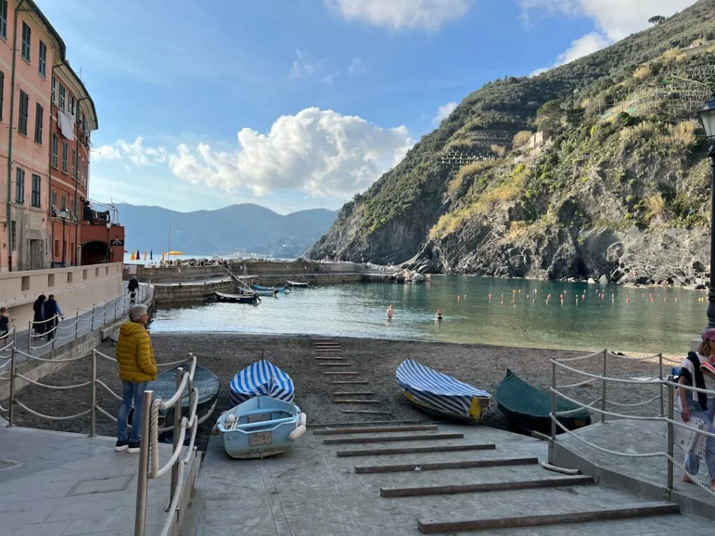 Barque sur cale et plage abritée à Cinque Terre, falaises en arrière-plan