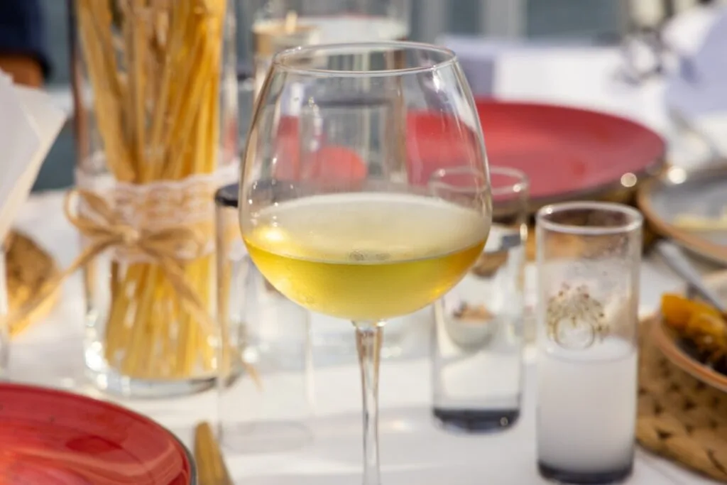 Verre de vin blanc local posé sur une table de restaurant à Cinque Terre