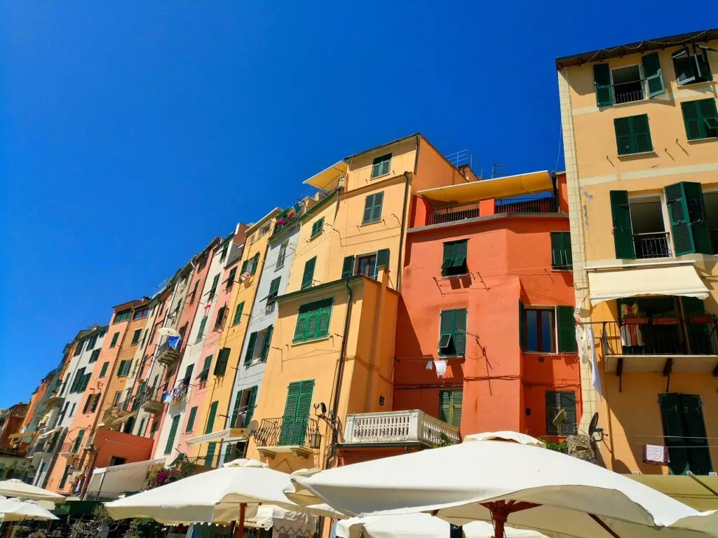 Gekleurde gevels met groene luiken en parasols in Cinque Terre