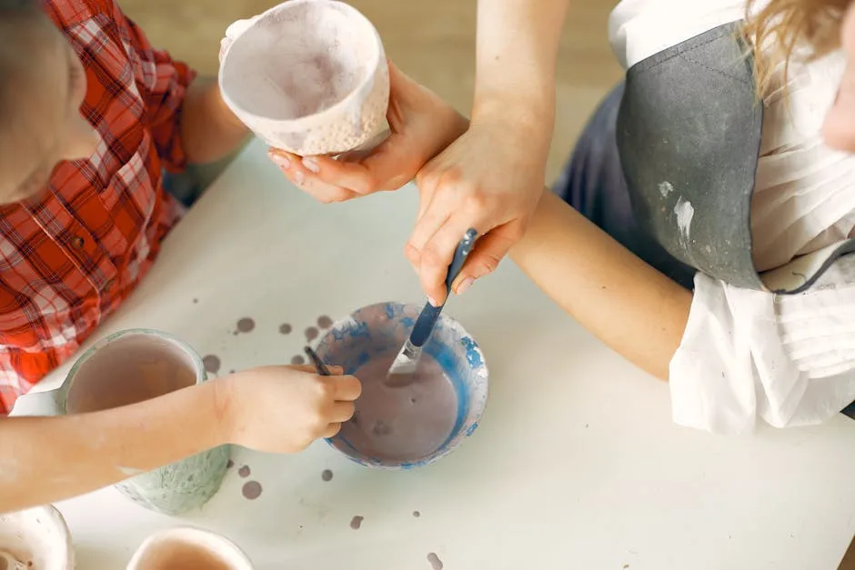 Mains d'enfants peignant des poteries dans un atelier à Cinque Terre