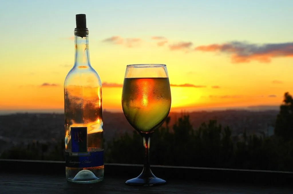 Verre et bouteille de vin blancs au coucher du soleil aux Cinque Terre