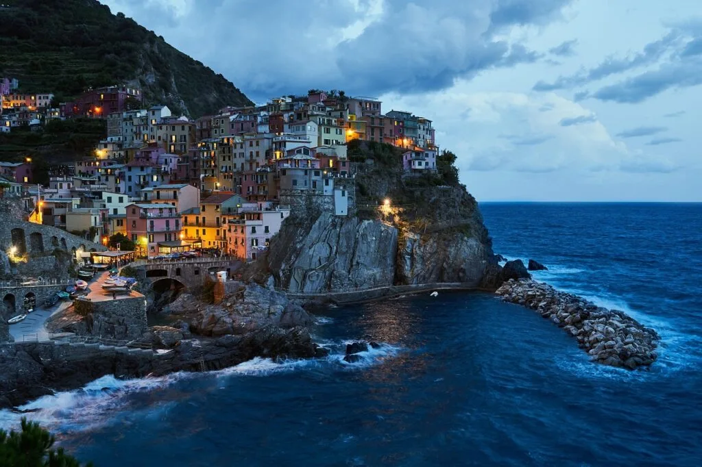 Manarola, village de Cinque Terre illuminé au crépuscule sur falaise