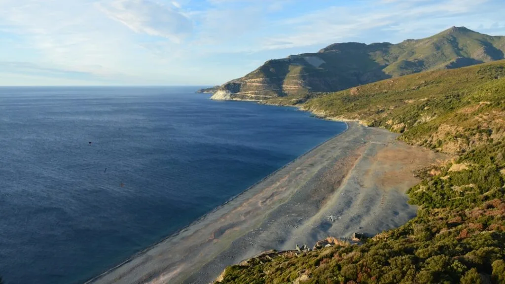 Large plage et côte rocheuse avec collines vertes de Cinque Terre