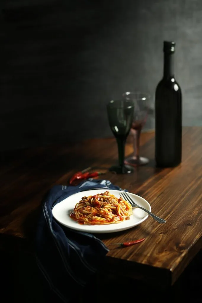 Bord spaghetti met pittige saus en wijnfles op tafel in Cinque Terre