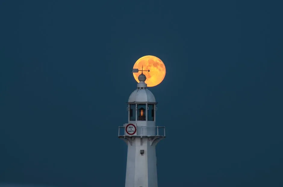 Pleine lune orange se levant derrière le phare des Cinque Terre