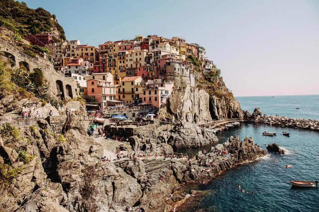 Village perché de Cinque Terre avec rochers, baigneurs et petites barques