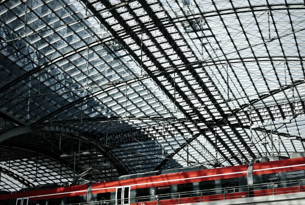 Train rouge stationné sous une verrière métallique, gare d'arrivée vers Cinque Terre