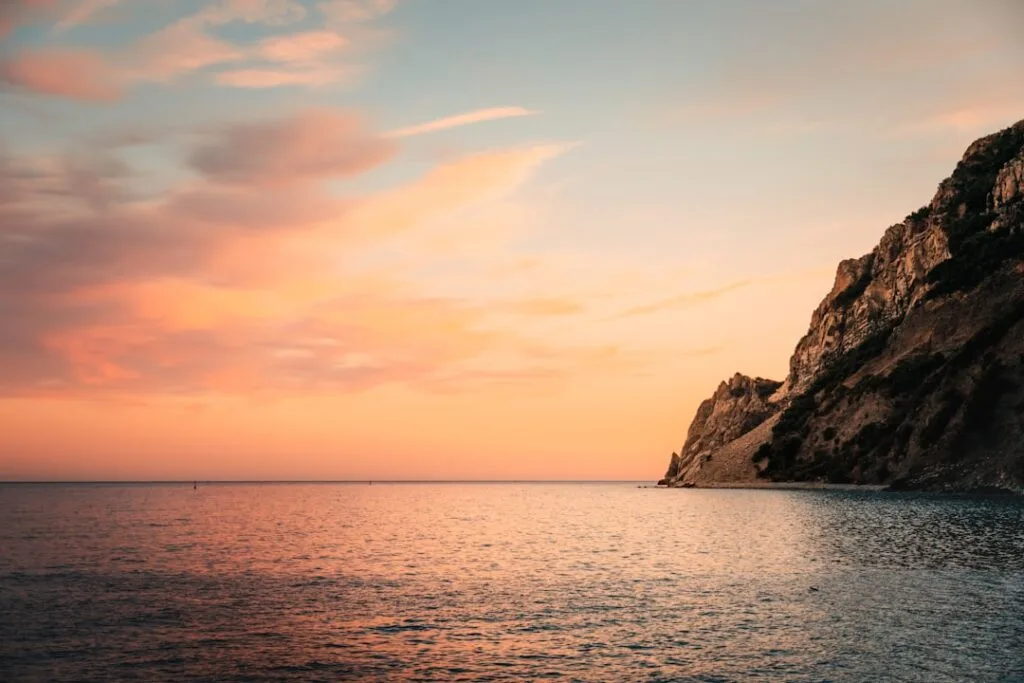 Côte rocheuse des Cinque Terre au coucher de soleil, mer calme
